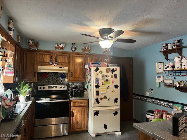 kitchen featuring decorative backsplash, white refrigerator, electric range, ceiling fan, and a textured ceiling