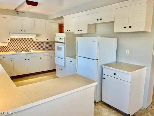 kitchen featuring white appliances, custom exhaust hood, and white cabinets