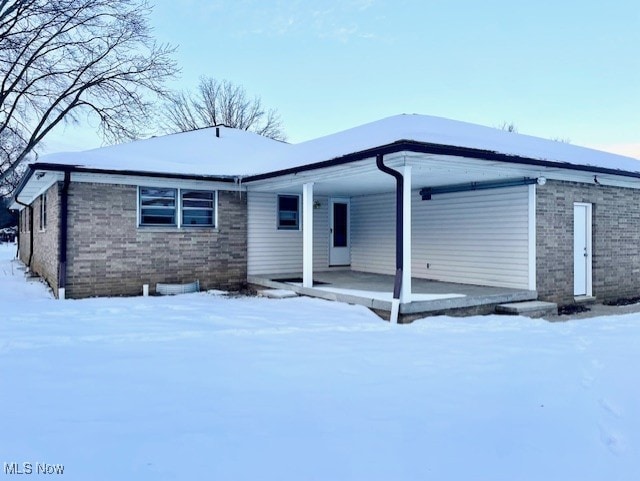 snow covered property with a porch