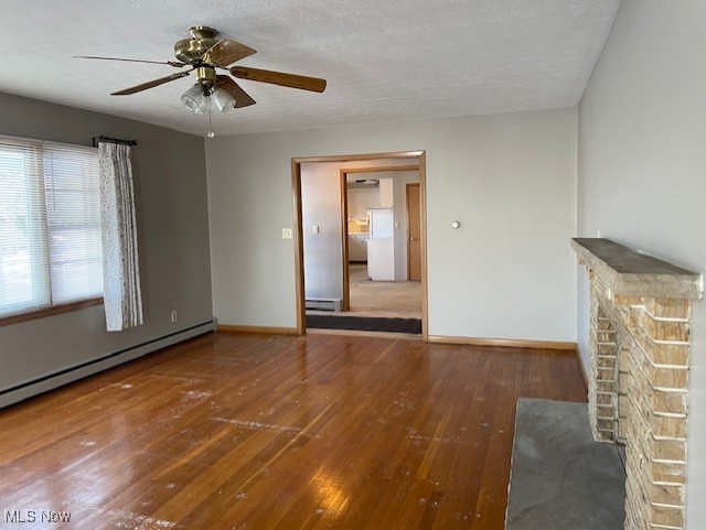 unfurnished living room with wood-type flooring, a baseboard heating unit, ceiling fan, and a textured ceiling