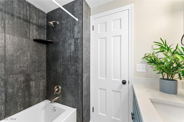 bathroom featuring vanity and tiled shower / bath