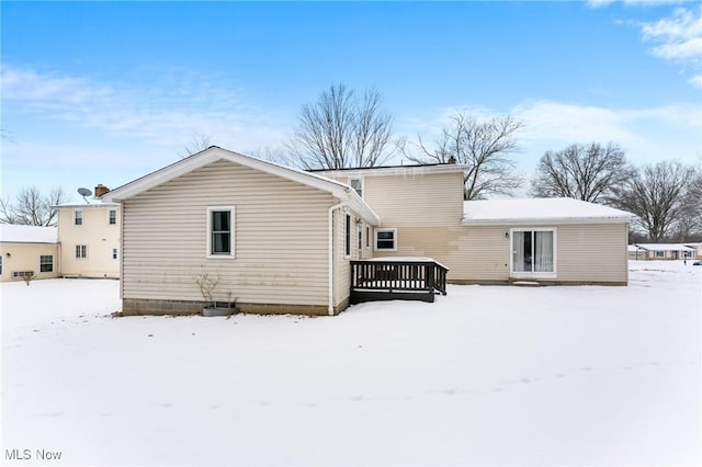 snow covered rear of property featuring a deck