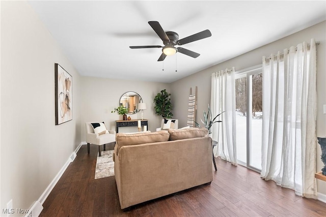 living room featuring ceiling fan and dark hardwood / wood-style floors