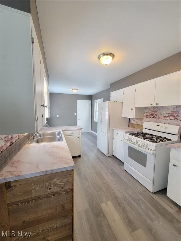 kitchen with white cabinetry, sink, backsplash, light hardwood / wood-style floors, and white appliances