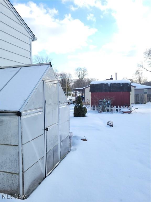 yard covered in snow featuring an outbuilding