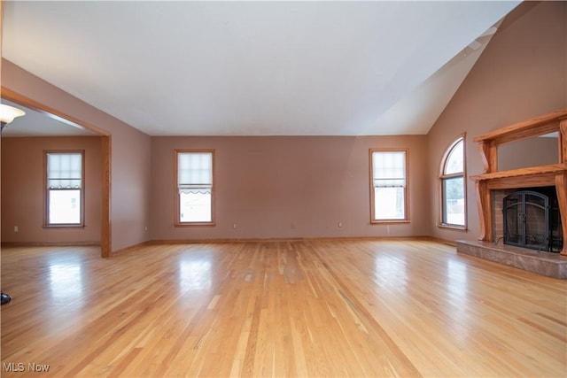 unfurnished living room featuring lofted ceiling and light wood-type flooring