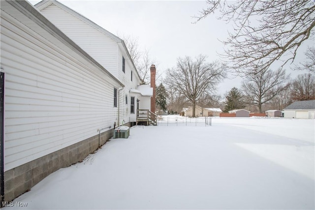 yard covered in snow featuring central air condition unit