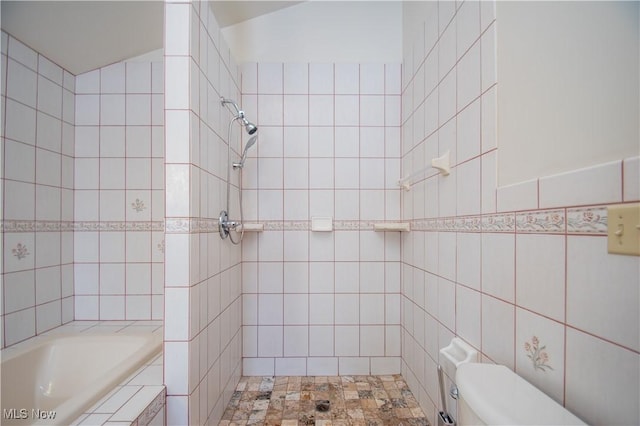 bathroom featuring toilet and tile walls