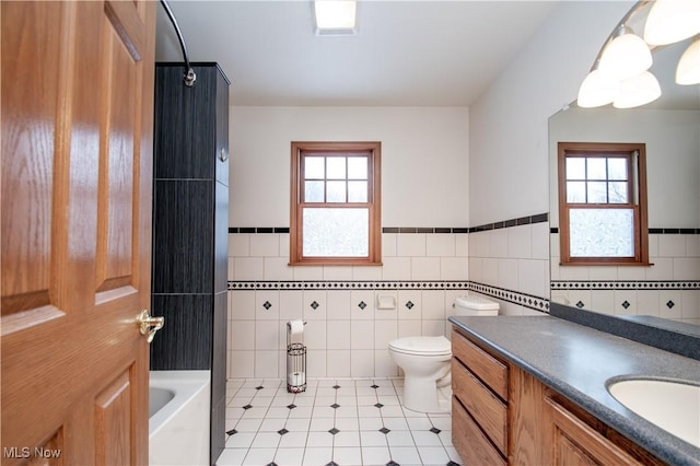 full bathroom with a wealth of natural light, tile walls, vanity, and toilet