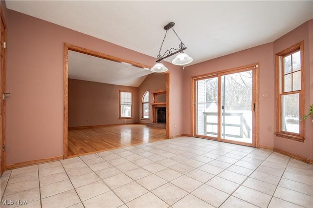 unfurnished living room with lofted ceiling and light tile patterned floors