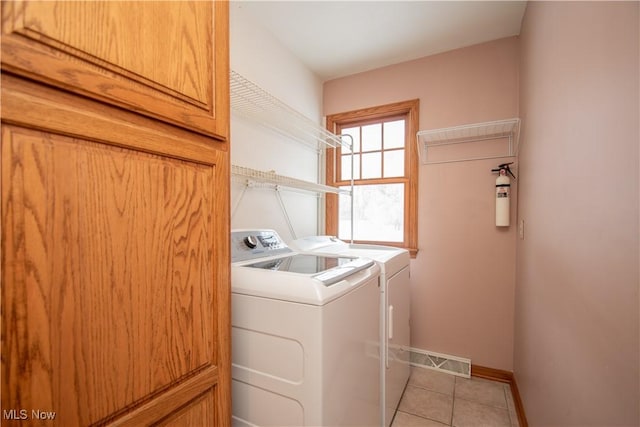 laundry room featuring light tile patterned floors and washer and clothes dryer