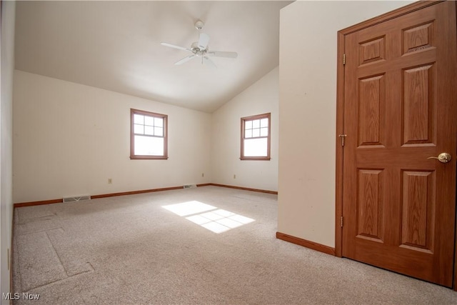 unfurnished room with light carpet, vaulted ceiling, and ceiling fan