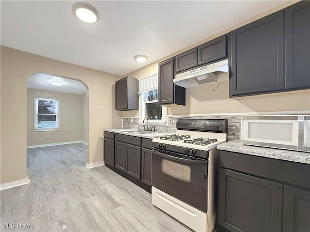 kitchen featuring white appliances, sink, and light wood-type flooring