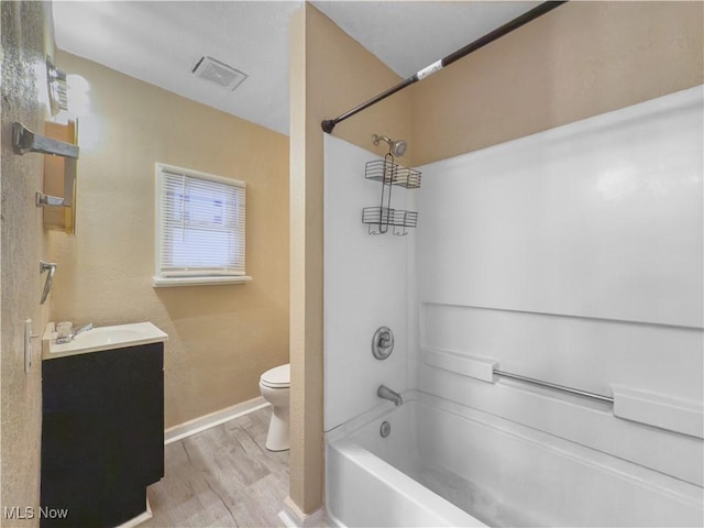 full bathroom with vanity, bathing tub / shower combination, hardwood / wood-style floors, and toilet