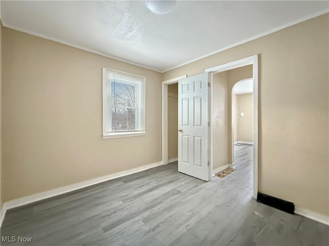 unfurnished bedroom with ornamental molding and light hardwood / wood-style floors