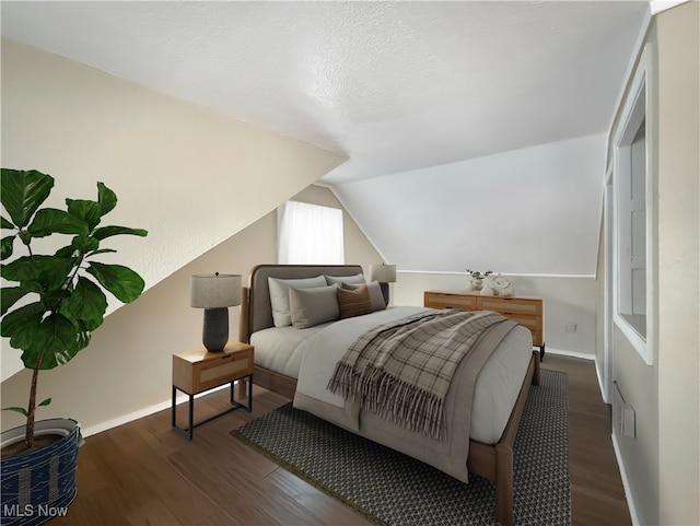 bedroom featuring lofted ceiling and dark wood-type flooring