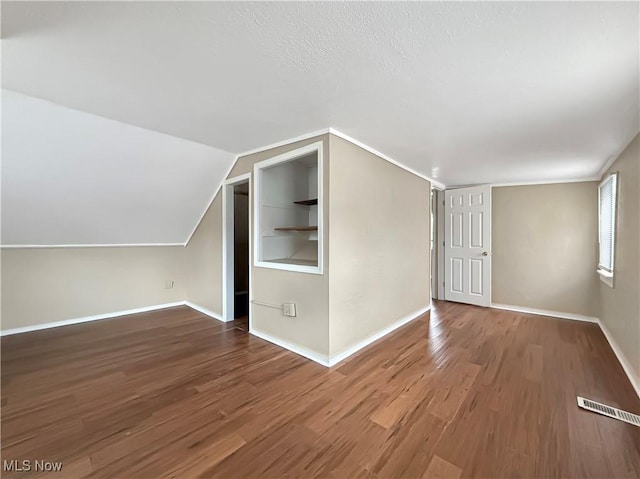 bonus room featuring wood-type flooring and vaulted ceiling