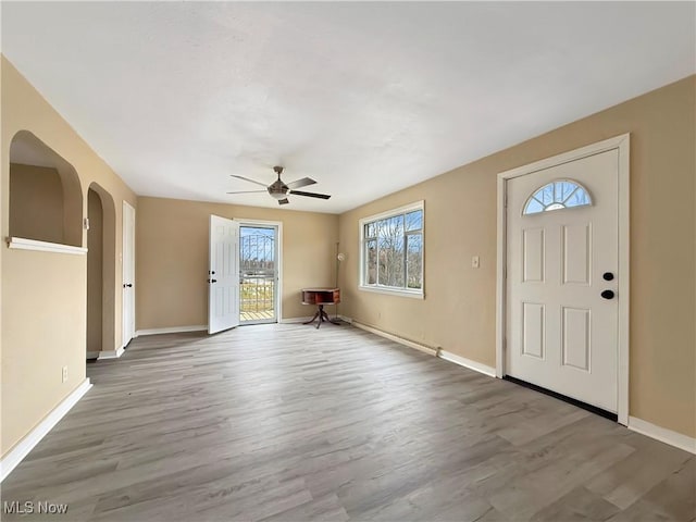 foyer entrance with ceiling fan and light hardwood / wood-style floors