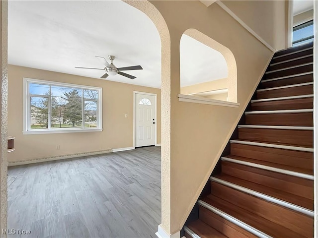 entryway featuring baseboard heating, ceiling fan, and wood-type flooring