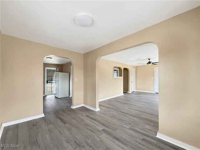 empty room with ceiling fan and wood-type flooring