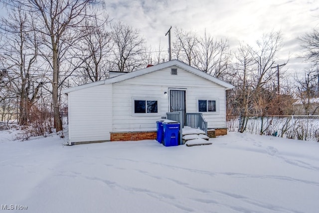 view of snow covered back of property