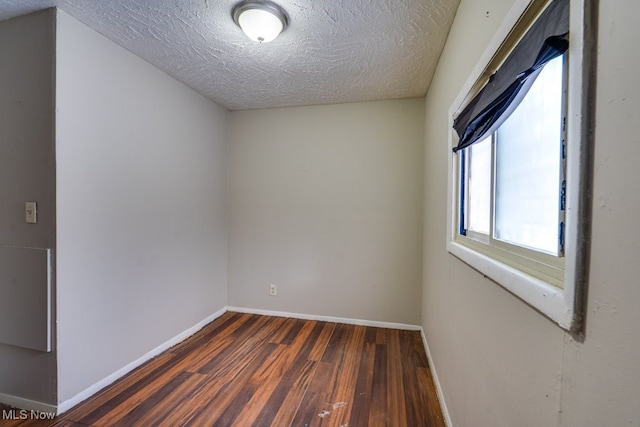 empty room featuring dark hardwood / wood-style flooring and a textured ceiling