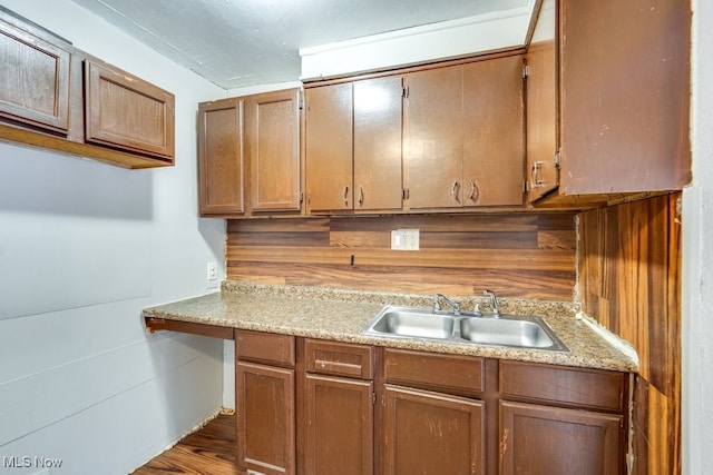 kitchen featuring sink, dark wood-type flooring, and wooden walls