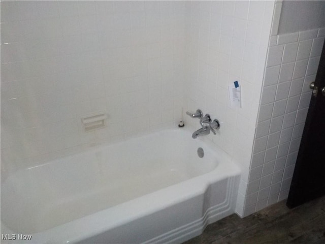 bathroom featuring hardwood / wood-style flooring and tiled shower / bath