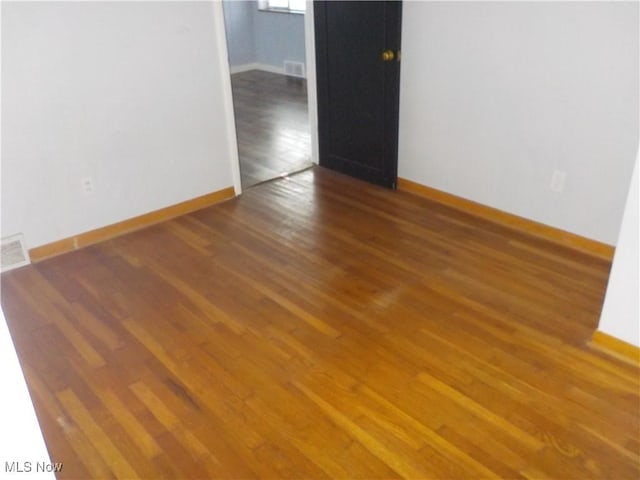 unfurnished room featuring dark hardwood / wood-style flooring