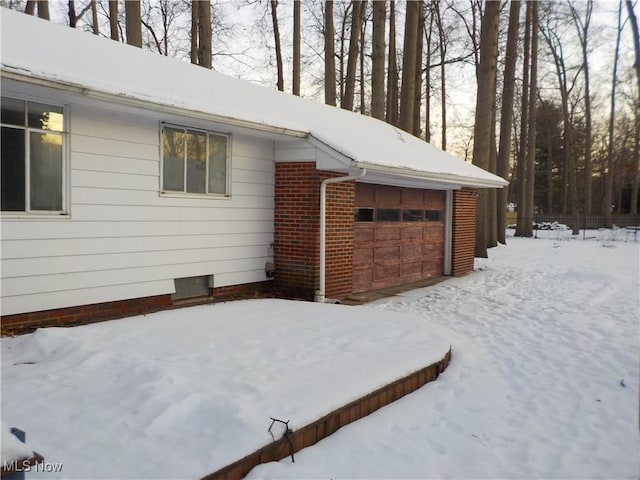 view of snowy exterior with a garage