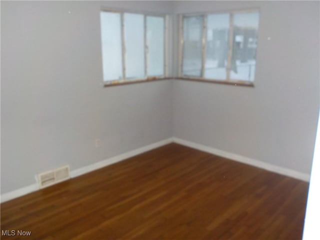 unfurnished room with dark hardwood / wood-style flooring