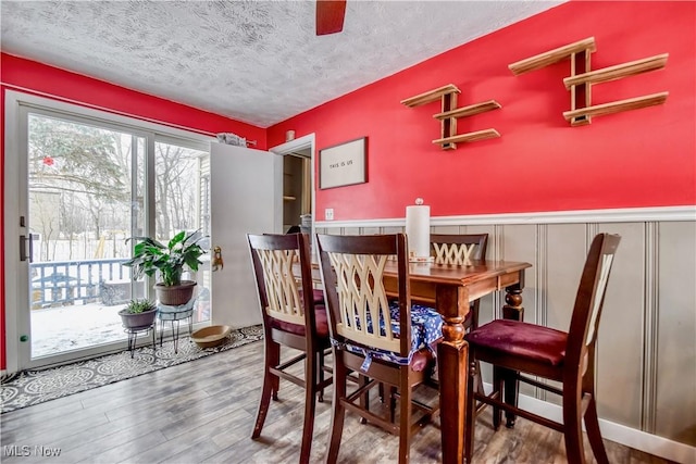 dining area with hardwood / wood-style flooring and a textured ceiling