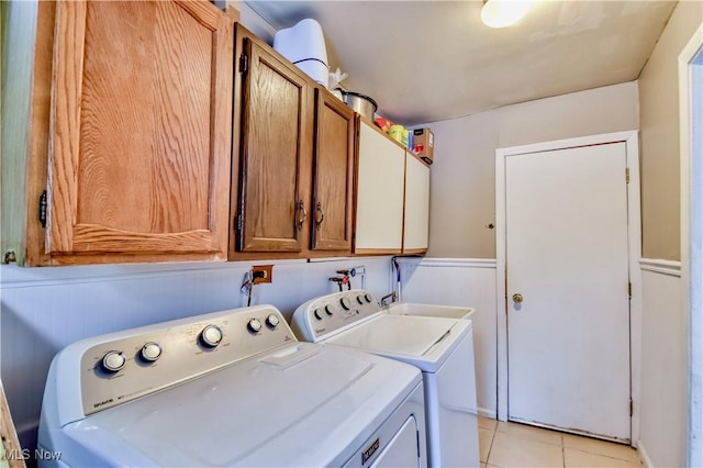 laundry room featuring light tile patterned floors, sink, washer and clothes dryer, and cabinets