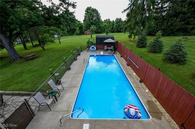 view of pool with a lawn and a shed