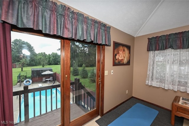 entryway featuring carpet floors, a textured ceiling, and vaulted ceiling