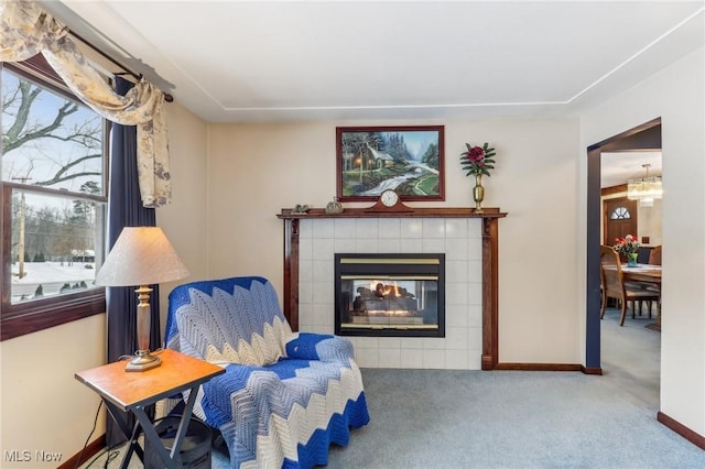 living area featuring a tiled fireplace and carpet