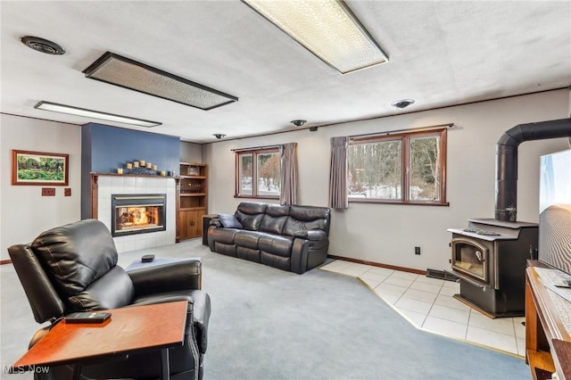 tiled living room featuring a fireplace and a wood stove