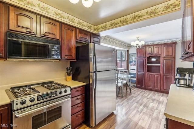 kitchen with stainless steel appliances, a notable chandelier, and light hardwood / wood-style flooring