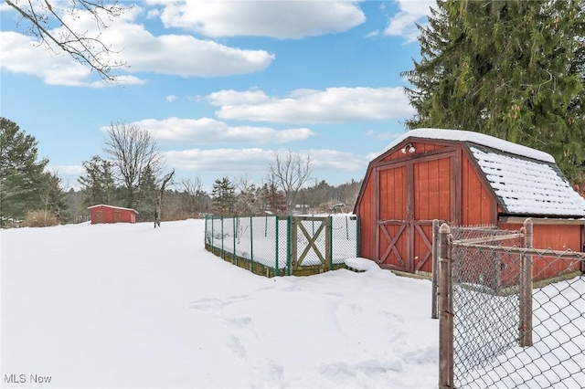 yard covered in snow featuring a storage shed