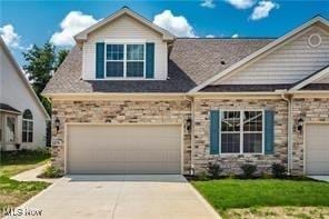 view of front of house with concrete driveway, an attached garage, and a front lawn