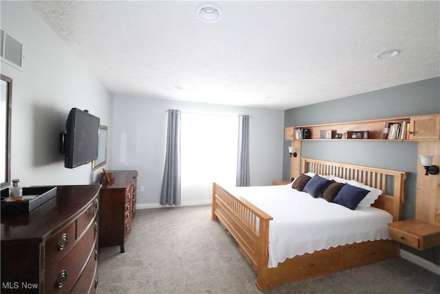 bedroom with visible vents, light carpet, and baseboards