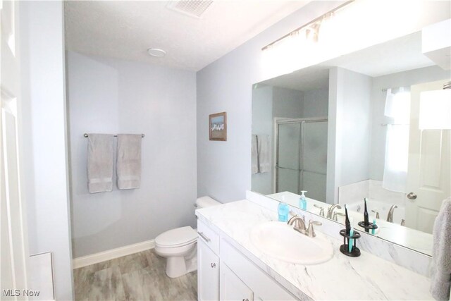 bathroom featuring visible vents, baseboards, toilet, a stall shower, and wood finished floors