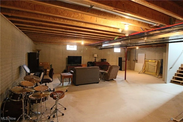 basement featuring stairs and brick wall