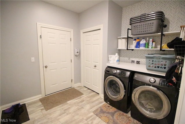 clothes washing area featuring laundry area, baseboards, and separate washer and dryer