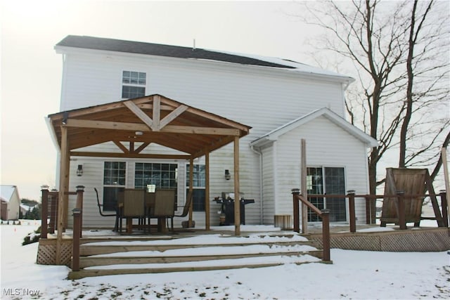 view of snow covered rear of property