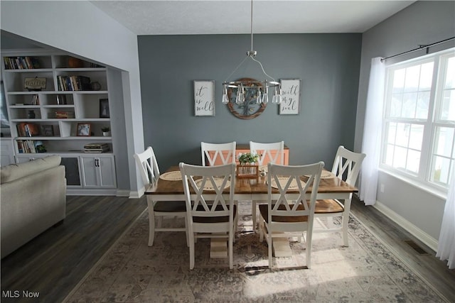 dining room featuring an inviting chandelier, wood finished floors, and a healthy amount of sunlight