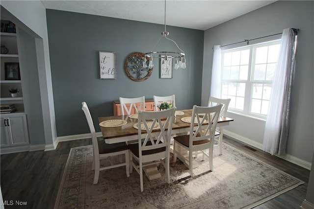 dining area with an inviting chandelier, baseboards, dark wood-style flooring, and visible vents