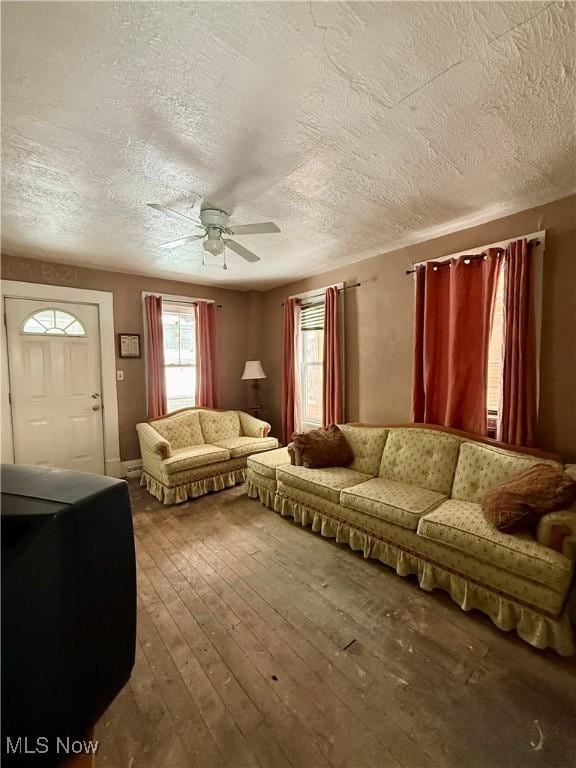 living room featuring hardwood / wood-style flooring, a textured ceiling, and ceiling fan