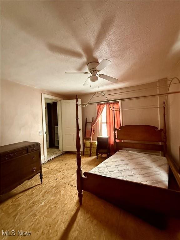 bedroom featuring ceiling fan and a textured ceiling