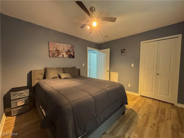 bedroom with ceiling fan, light hardwood / wood-style floors, and a closet